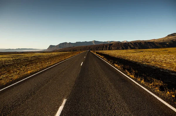 Road through Iceland landscape. Road and car travel scenic and sunset. Road travel concept. Car travel adventure. Travel concept. Freedom.