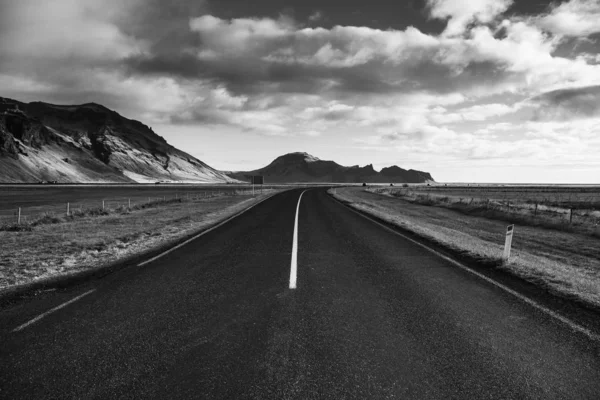 İzlanda 'ya giden yol. Yol ve araba manzaralı ve gün batımlı. Yolculuk konsepti. Araba yolculuğu macerası. Seyahat konsepti. Özgürlük.