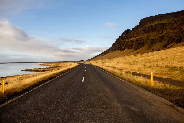 Road through Iceland landscape. Road and car travel scenic and sunset. Road travel concept. Car travel adventure. Travel concept. Freedom.