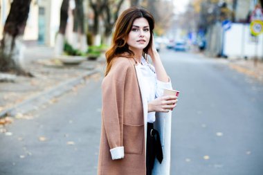 Şehir caddesinde çay içen şık bir kadın. Sokakta kahve bardaklı hippi Avrupalı kız. Şehir caddesinde elinde bir fincan kahveyle çok güzel bir genç bayan. Kahve molası. Kahve hazır.. 