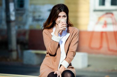 Şehir caddesinde çay içen şık bir kadın. Sokakta kahve bardaklı hippi Avrupalı kız. Şehir caddesinde elinde bir fincan kahveyle çok güzel bir genç bayan. Kahve molası. Kahve hazır.. 