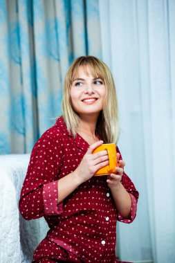 Genç güzel kadın ışık odada kirlenmiş. Rahat kadın pijamalar yatakta yatıyor. Günaydın kavramı - genç kadının uyanmanın mutlu gülümseme ile yüzünde.