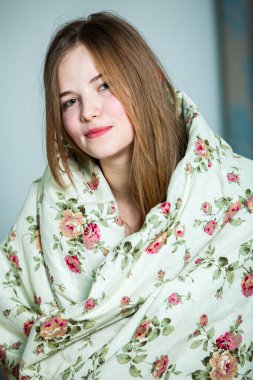 Genç, güzel, beyaz bir kadın aydınlık odada uyanıyor. Rahatlamış bir kadın yatakta uzanıp çay içiyor. Günaydın konsepti. Rus kız..