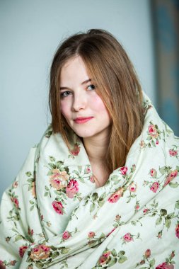 Genç, güzel, beyaz bir kadın aydınlık odada uyanıyor. Rahatlamış bir kadın yatakta uzanıp çay içiyor. Günaydın konsepti. Rus kız..