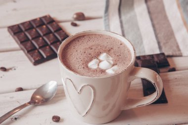 Two cups of hot cocoa with marshmallows and cinnamon sticks on wooden background. Love. Cocoa drink. Valentines day treat ideas.