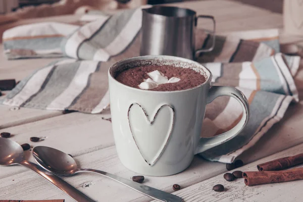 Two cups of hot cocoa with marshmallows and cinnamon sticks on wooden background. Love. Cocoa drink. Valentines day treat ideas.