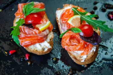 Appetizing bruschetta. Traditional Italian bruschetta. Open sandwich with salmon and vegetables. Delicious healthy food. European cuisine. 