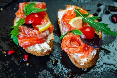 Appetizing bruschetta. Traditional Italian bruschetta. Open sandwich with salmon and vegetables. Delicious healthy food. European cuisine. 
