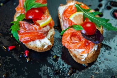 Appetizing bruschetta. Traditional Italian bruschetta. Open sandwich with salmon and vegetables. Delicious healthy food. European cuisine. 