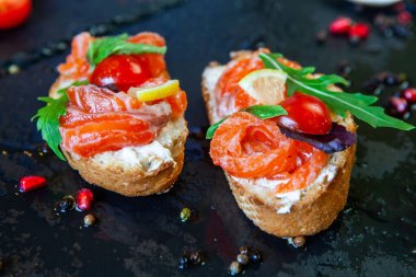 Appetizing bruschetta. Traditional Italian bruschetta. Open sandwich with salmon and vegetables. Delicious healthy food. European cuisine. 