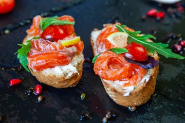 Appetizing bruschetta. Traditional Italian bruschetta. Open sandwich with salmon and vegetables. Delicious healthy food. European cuisine. 