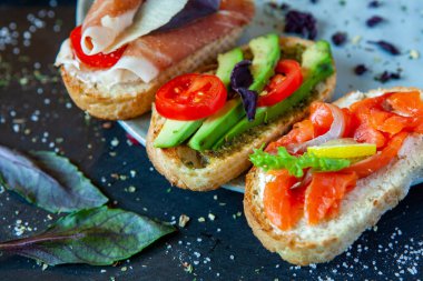 Appetizing bruschetta. Traditional Italian bruschetta. Open sandwich with salmon and vegetables. Delicious healthy food. European cuisine. 