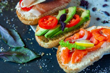 Appetizing bruschetta. Traditional Italian bruschetta. Open sandwich with salmon and vegetables. Delicious healthy food. European cuisine. 