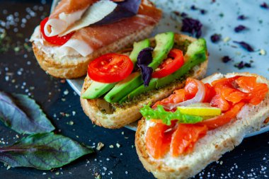 Appetizing bruschetta. Traditional Italian bruschetta. Open sandwich with salmon and vegetables. Delicious healthy food. European cuisine. 