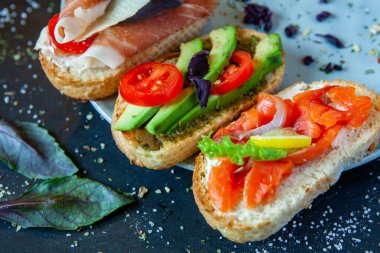 Appetizing bruschetta. Traditional Italian bruschetta. Open sandwich with salmon and vegetables. Delicious healthy food. European cuisine. 