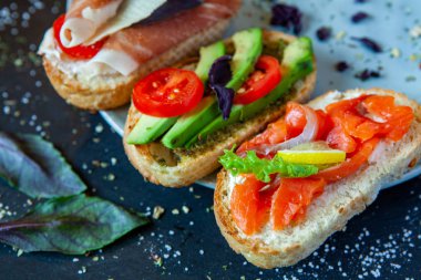 Appetizing bruschetta. Traditional Italian bruschetta. Open sandwich with salmon and vegetables. Delicious healthy food. European cuisine. 