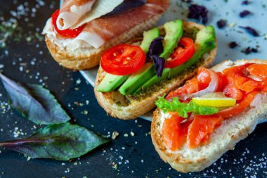 Appetizing bruschetta. Traditional Italian bruschetta. Open sandwich with salmon and vegetables. Delicious healthy food. European cuisine. 