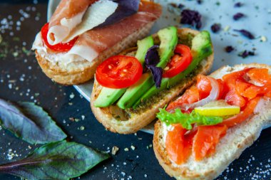 Appetizing bruschetta. Traditional Italian bruschetta. Open sandwich with salmon and vegetables. Delicious healthy food. European cuisine. 
