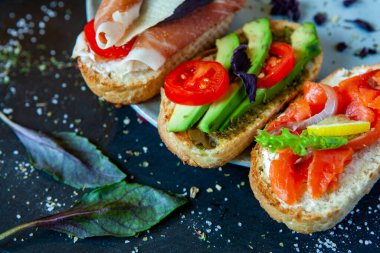 Appetizing bruschetta. Traditional Italian bruschetta. Open sandwich with salmon and vegetables. Delicious healthy food. European cuisine. 