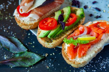 Appetizing bruschetta. Traditional Italian bruschetta. Open sandwich with salmon and vegetables. Delicious healthy food. European cuisine. 
