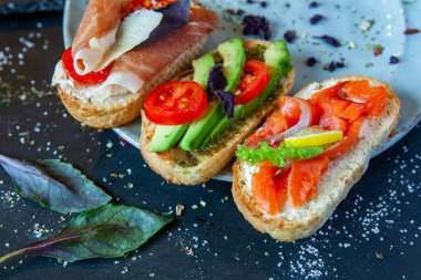 Appetizing bruschetta. Traditional Italian bruschetta. Open sandwich with salmon and vegetables. Delicious healthy food. European cuisine. 