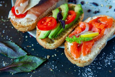 Appetizing bruschetta. Traditional Italian bruschetta. Open sandwich with salmon and vegetables. Delicious healthy food. European cuisine. 