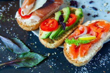 Appetizing bruschetta. Traditional Italian bruschetta. Open sandwich with salmon and vegetables. Delicious healthy food. European cuisine. 