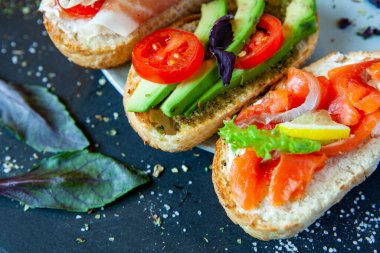 Appetizing bruschetta. Traditional Italian bruschetta. Open sandwich with salmon and vegetables. Delicious healthy food. European cuisine. 