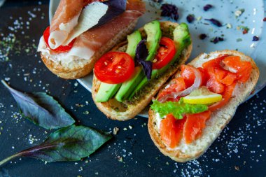 Appetizing bruschetta. Traditional Italian bruschetta. Open sandwich with salmon and vegetables. Delicious healthy food. European cuisine. 