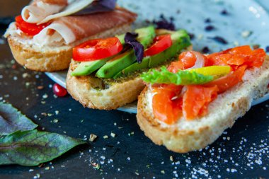 Appetizing bruschetta. Traditional Italian bruschetta. Open sandwich with salmon and vegetables. Delicious healthy food. European cuisine. 