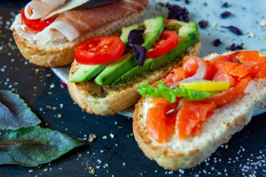 Appetizing bruschetta. Traditional Italian bruschetta. Open sandwich with salmon and vegetables. Delicious healthy food. European cuisine. 