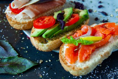 Appetizing bruschetta. Traditional Italian bruschetta. Open sandwich with salmon and vegetables. Delicious healthy food. European cuisine. 