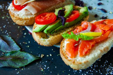 Appetizing bruschetta. Traditional Italian bruschetta. Open sandwich with salmon and vegetables. Delicious healthy food. European cuisine. 