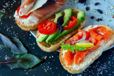 Appetizing bruschetta. Traditional Italian bruschetta. Open sandwich with salmon and vegetables. Delicious healthy food. European cuisine. 