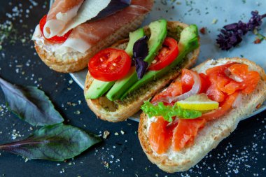 Appetizing bruschetta. Traditional Italian bruschetta. Open sandwich with salmon and vegetables. Delicious healthy food. European cuisine. 