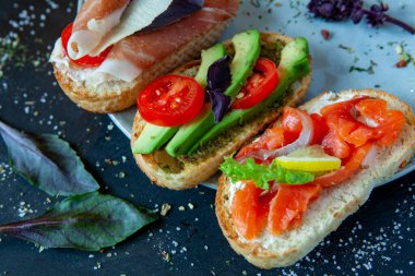 Appetizing bruschetta. Traditional Italian bruschetta. Open sandwich with salmon and vegetables. Delicious healthy food. European cuisine. 