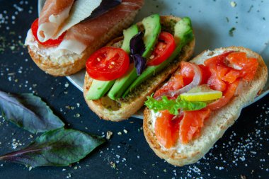 Appetizing bruschetta. Traditional Italian bruschetta. Open sandwich with salmon and vegetables. Delicious healthy food. European cuisine. 
