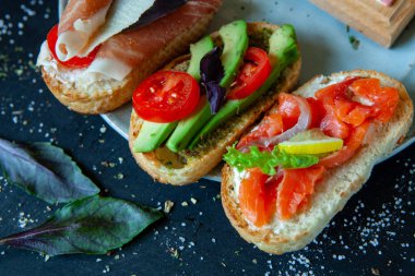 Appetizing bruschetta. Traditional Italian bruschetta. Open sandwich with salmon and vegetables. Delicious healthy food. European cuisine. 