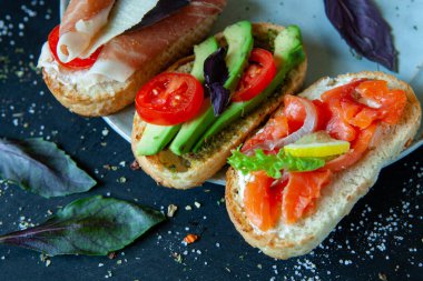 Appetizing bruschetta. Traditional Italian bruschetta. Open sandwich with salmon and vegetables. Delicious healthy food. European cuisine. 