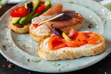 Appetizing bruschetta. Traditional Italian bruschetta. Open sandwich with salmon and vegetables. Delicious healthy food. European cuisine. 