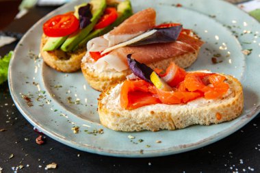 Appetizing bruschetta. Traditional Italian bruschetta. Open sandwich with salmon and vegetables. Delicious healthy food. European cuisine. 