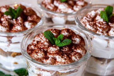 Tiramisu cake in glass, classic Italian dessert with mascarpone cream and cocoa. selective focus.