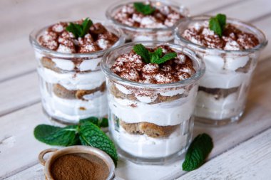Tiramisu cake in glass, classic Italian dessert with mascarpone cream and cocoa. selective focus.