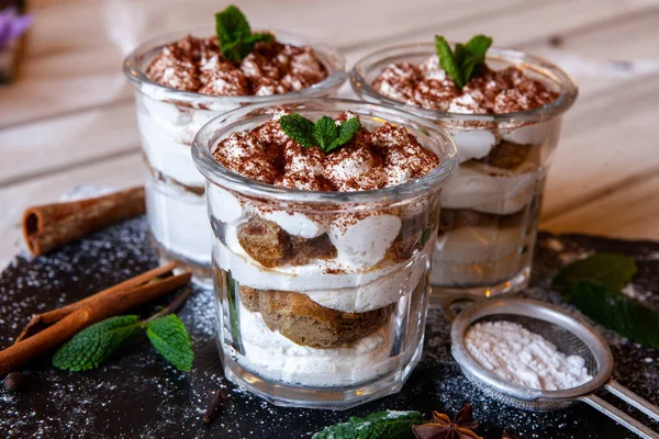 Tiramisu cake in glass, classic Italian dessert with mascarpone cream and cocoa. selective focus.