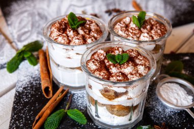 Tiramisu cake in glass, classic Italian dessert with mascarpone cream and cocoa. selective focus.