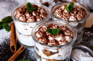 Tiramisu cake in glass, classic Italian dessert with mascarpone cream and cocoa. selective focus.