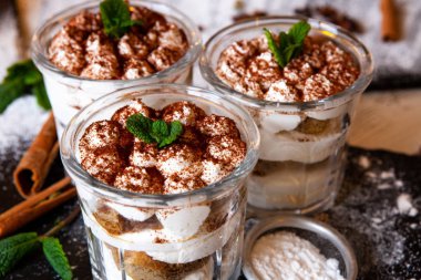 Tiramisu cake in glass, classic Italian dessert with mascarpone cream and cocoa. selective focus.