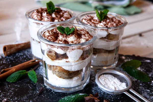 Tiramisu cake in glass, classic Italian dessert with mascarpone cream and cocoa. selective focus.