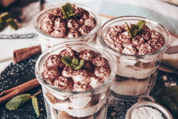 Tiramisu cake in glass, classic Italian dessert with mascarpone cream and cocoa. selective focus.