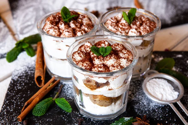 Tiramisu cake in glass, classic Italian dessert with mascarpone cream and cocoa. selective focus.